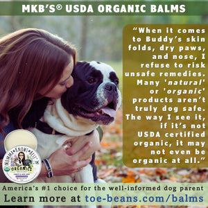 Woman kissing black and white dog with MKB Paw and Nose Balm